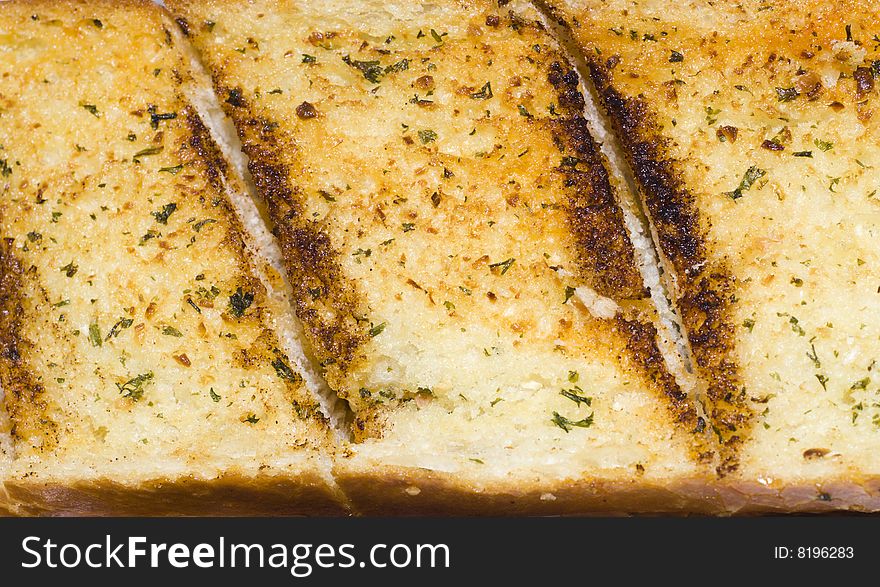 Slice of golden garlic bread with herbs. Slice of golden garlic bread with herbs.