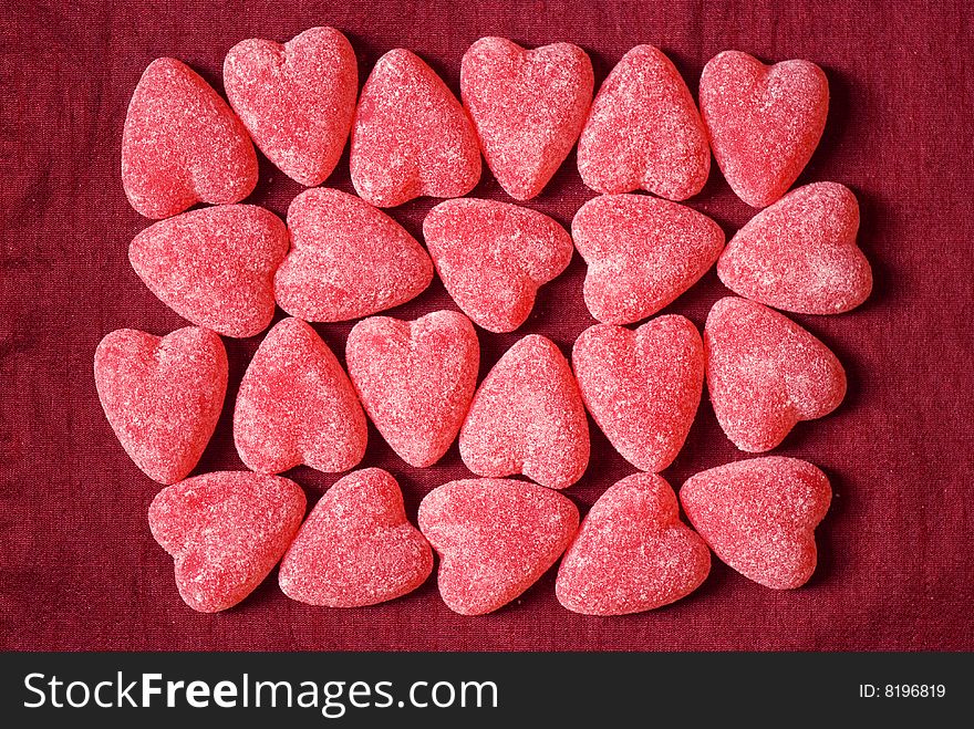 Red sugar hearts over fabric background