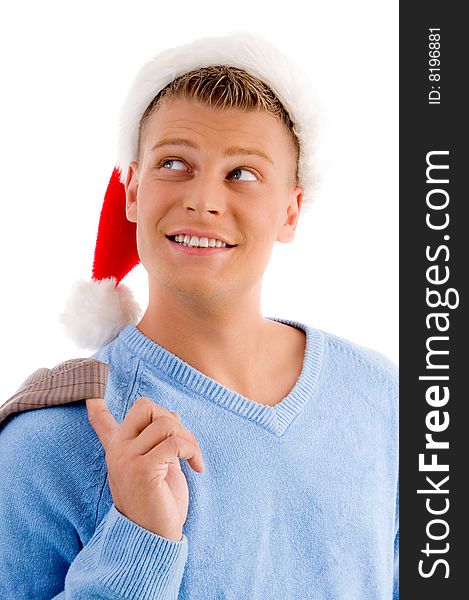 Smiling young man with christmas hat looking upside on an isolated background. Smiling young man with christmas hat looking upside on an isolated background