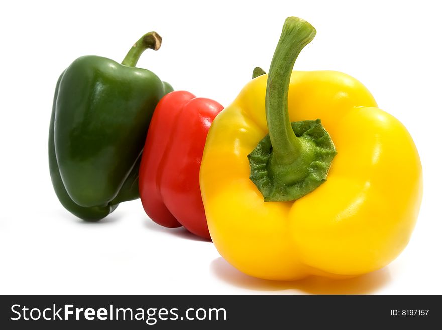 Three different color peppers on white background. focus on the yellow one.