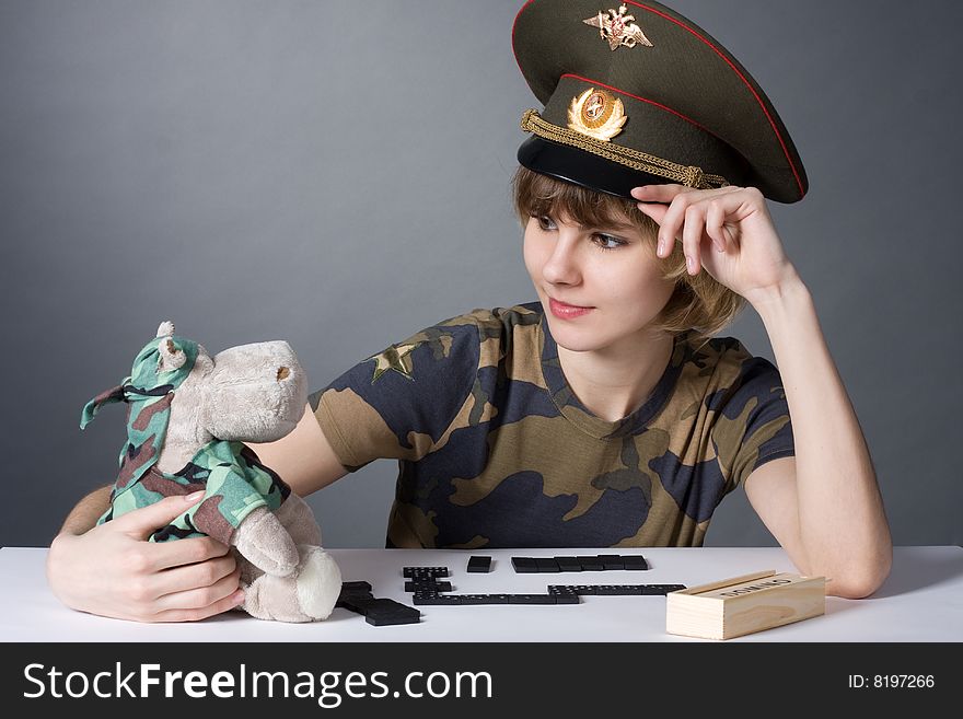 Beautiful young girl in form of Russian army smiling with toy