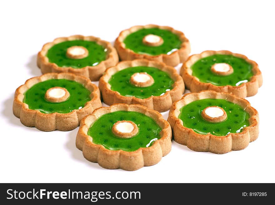 Cakes with green jelly in form of flower on white background