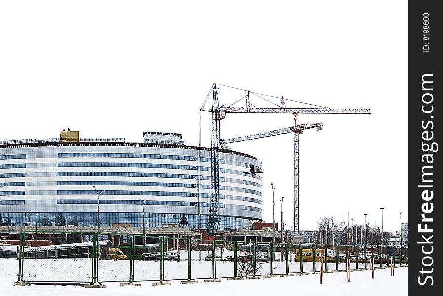 Building with lifting crane in winter