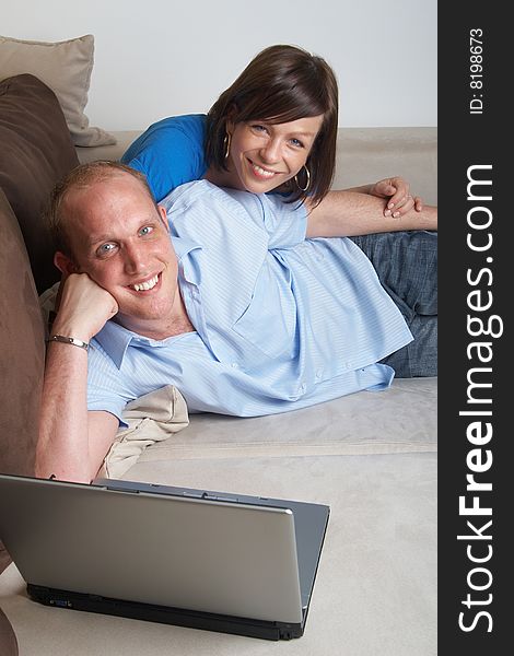 Young couple on the couch at home looking at the laptop!. Young couple on the couch at home looking at the laptop!