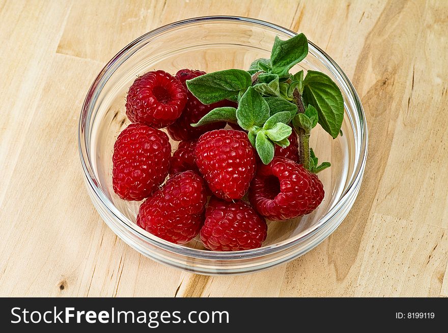 Fresh ripe raspberry whith mint leaves in glass jam dish