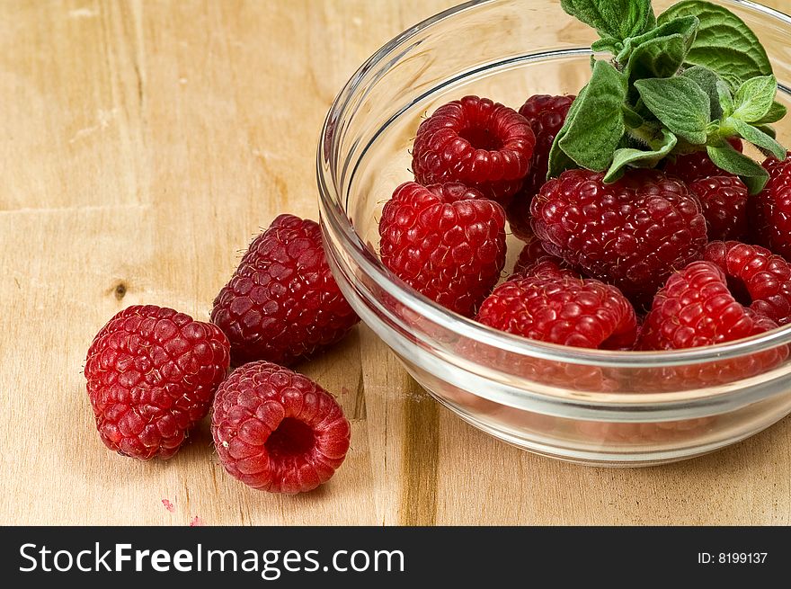 Fresh ripe raspberry whith mint leaves in glass jam dish