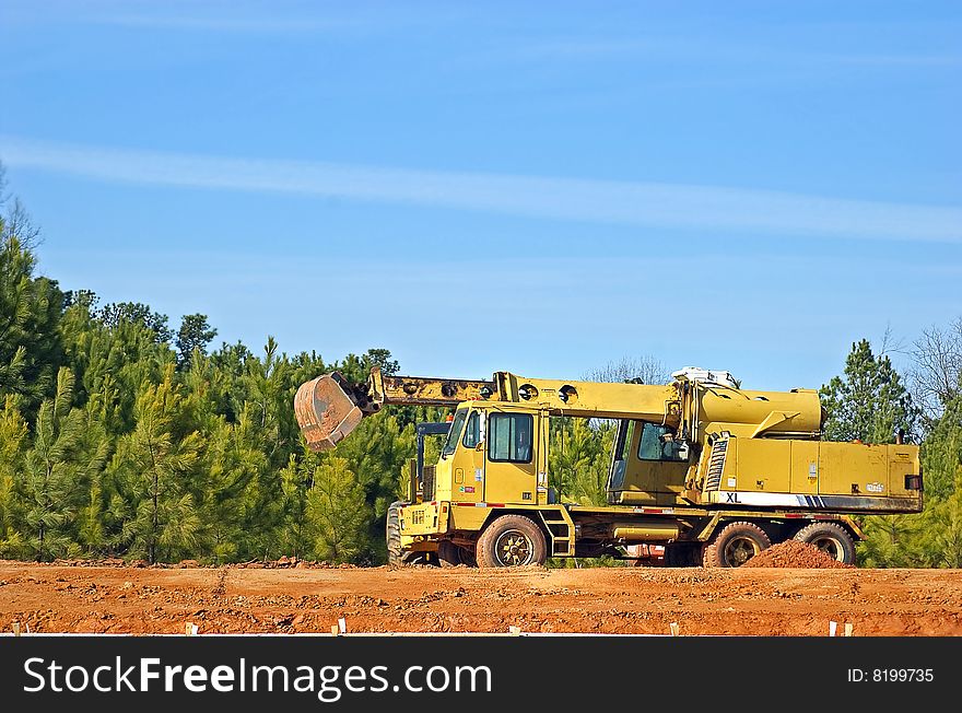 Yellow construction machinery against blue sky.