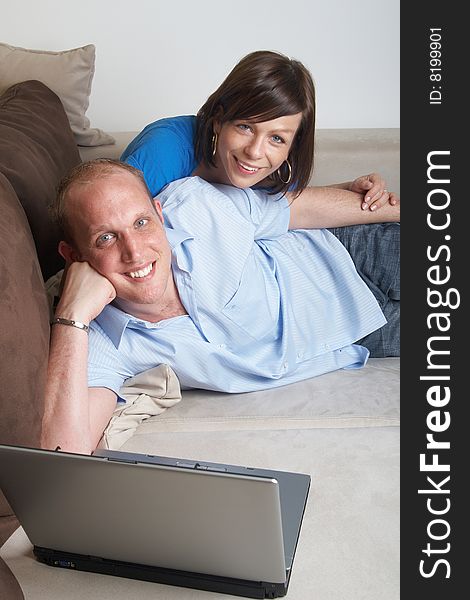 Young couple on the couch at home looking at the laptop!. Young couple on the couch at home looking at the laptop!