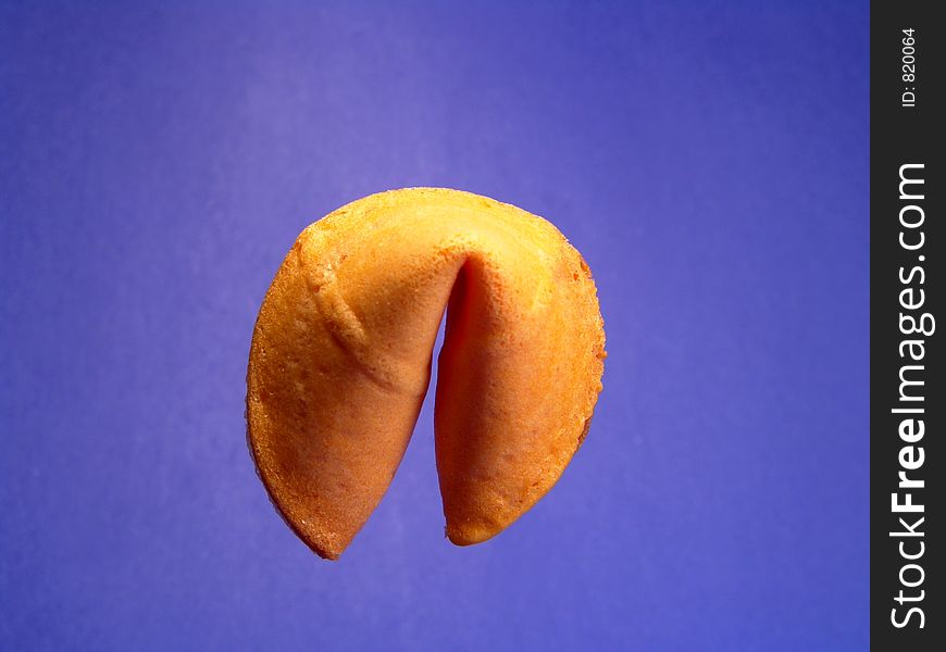 A single fortune cookie isolated and suspending in the air. A single fortune cookie isolated and suspending in the air