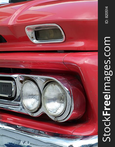 Front detail of red American pickup truck from the sixties. Front detail of red American pickup truck from the sixties