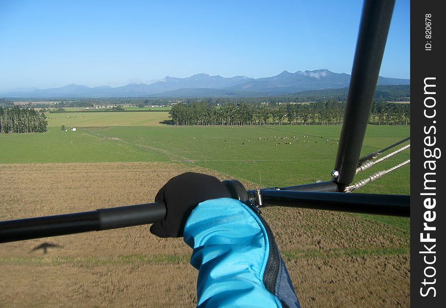 Aerial view of a farm and mountain range taken during take-off from the open air cockpit of a microlight. Aerial view of a farm and mountain range taken during take-off from the open air cockpit of a microlight.