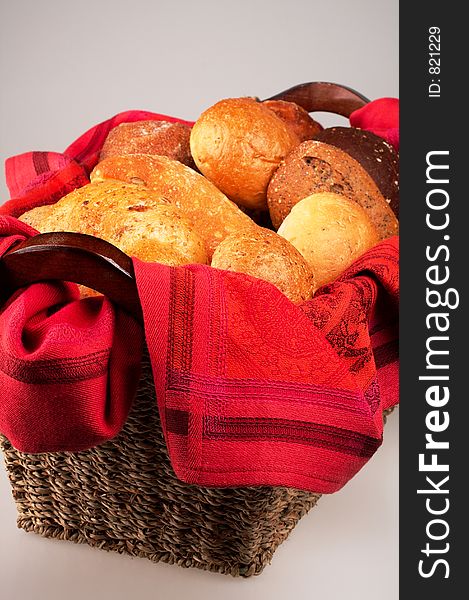 An elegant setting of dinner breads in a woven basket lined with a luxuriously red cloth. An elegant setting of dinner breads in a woven basket lined with a luxuriously red cloth.