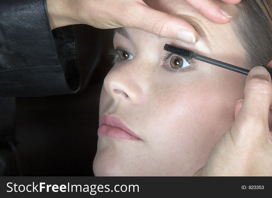 Make-up artist applying mascara to young woman?s lashes