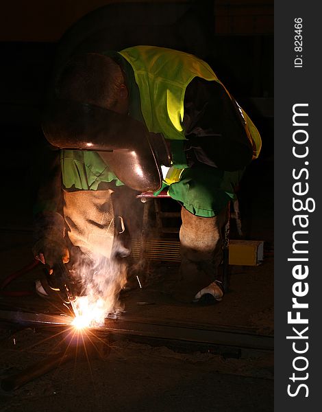 A welder is working at night