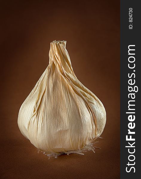 An upright single garlic bulb. An upright single garlic bulb