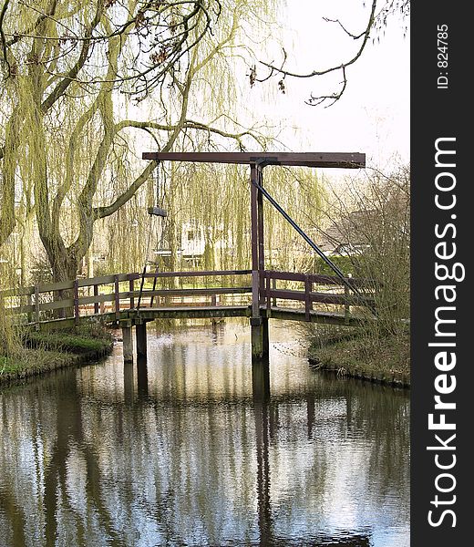 A wooden bridge over a small pond in the park