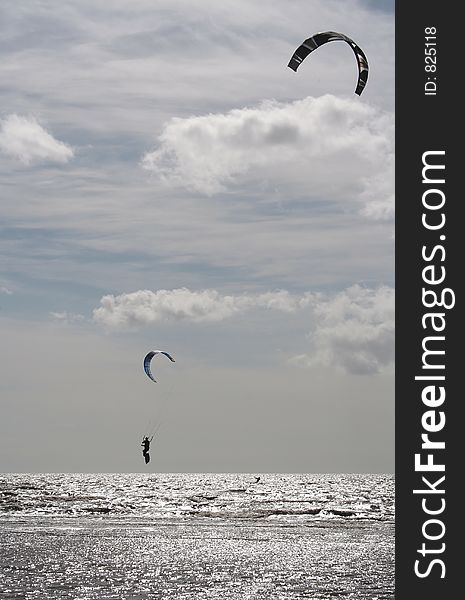 Kiteboarder gets big air at beach. Kiteboarder gets big air at beach