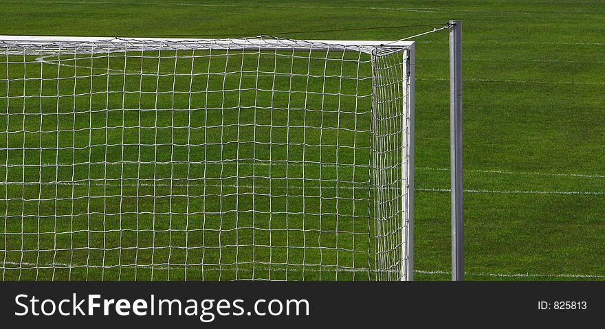 Cropped shot of the right side of a soccer goal standing in a lush green grass field. Cropped shot of the right side of a soccer goal standing in a lush green grass field