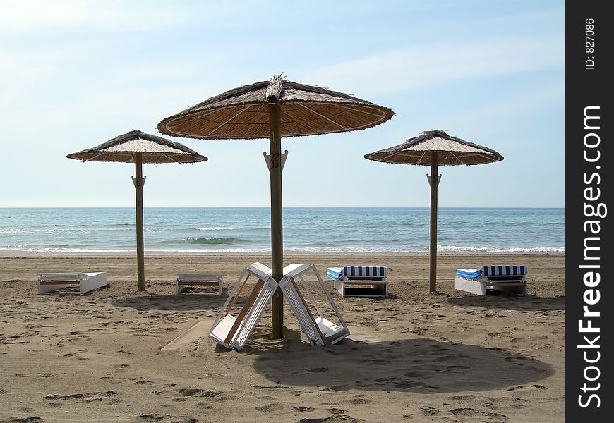 Three umbrellas with two chairs each one in the beach. Three umbrellas with two chairs each one in the beach