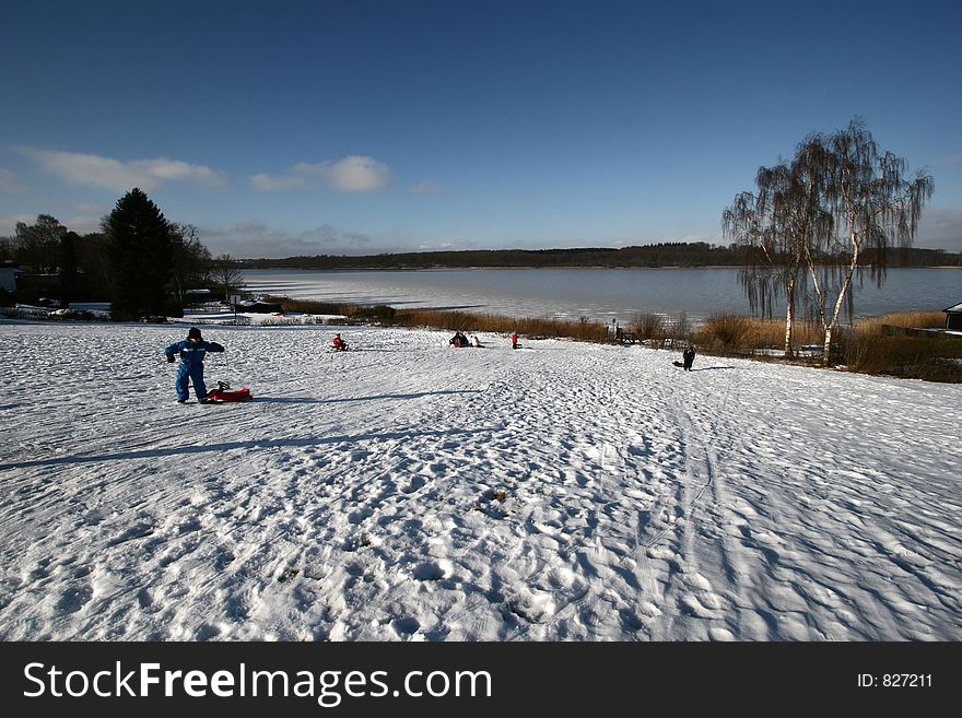 In the country nearby  a lake in winter, children playing. In the country nearby  a lake in winter, children playing
