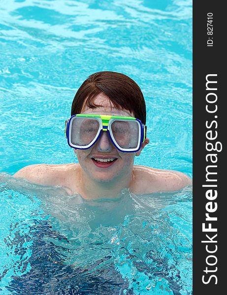 Adolescent boy in pool wearing swim gogles. Adolescent boy in pool wearing swim gogles