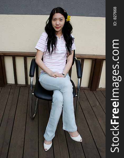 Pretty Korean girl sitting in a chair. Pretty Korean girl sitting in a chair