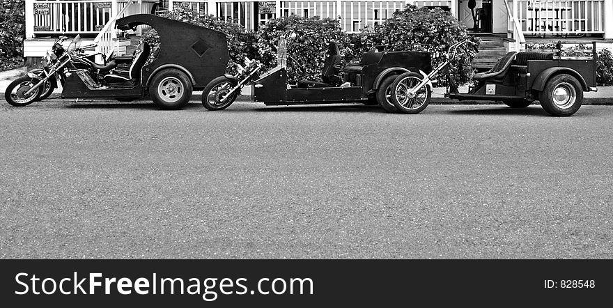 Three Black and White Trikes parked along curb. Plenty of space for copy.