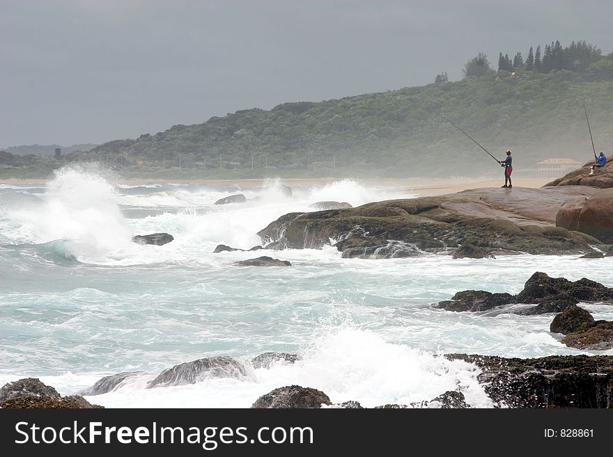 Angler On A Rocky Shore