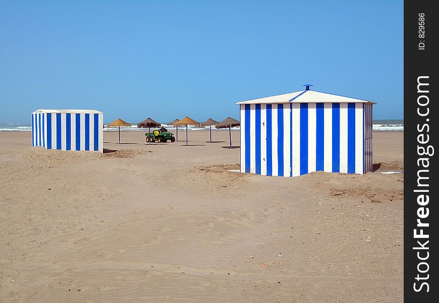 Two Beach Cabins And Umbrellas