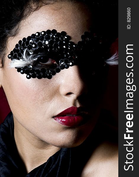 Attractive young Hispanic woman wearing a black gem mask. Attractive young Hispanic woman wearing a black gem mask