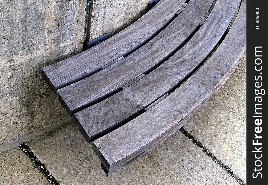 An urban plaza bench made of wood and concrete in strong light, shadow, and contrast. An urban plaza bench made of wood and concrete in strong light, shadow, and contrast.