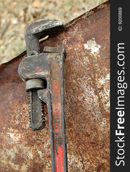 Old adjustable wrench on a rusty background. Old adjustable wrench on a rusty background