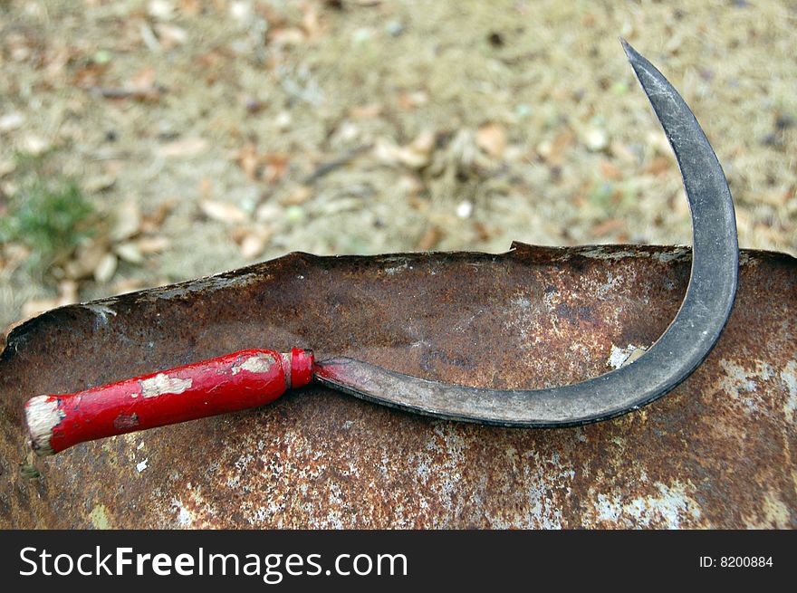 Old cutter with red handle used by farmers