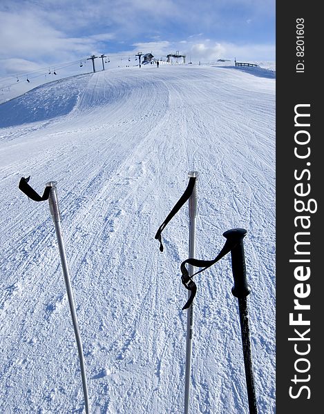 Three ski sticks with lift in the background