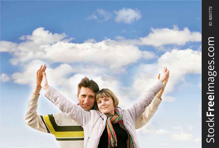 Young happy couple over sky background