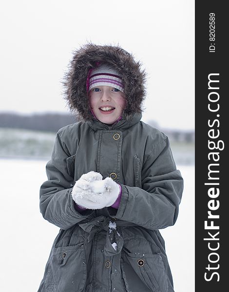 Girl playing in the snow makin snow balls. Girl playing in the snow makin snow balls