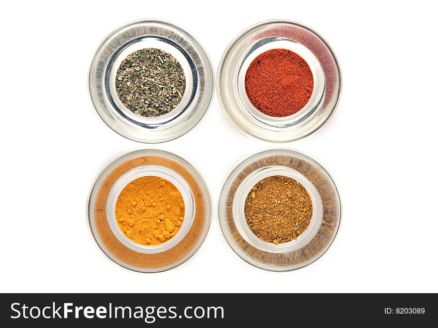 Four colorful spices in glass containers isolated on white background. Four colorful spices in glass containers isolated on white background