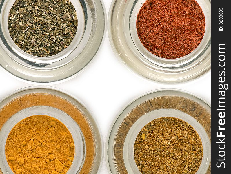 Colorful spices in glass containers closeup isolated. Colorful spices in glass containers closeup isolated