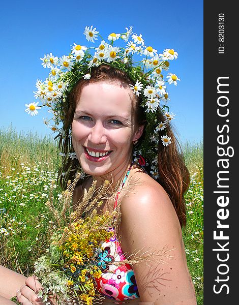 Portrait of a beautiful girl in the wreath of daisies