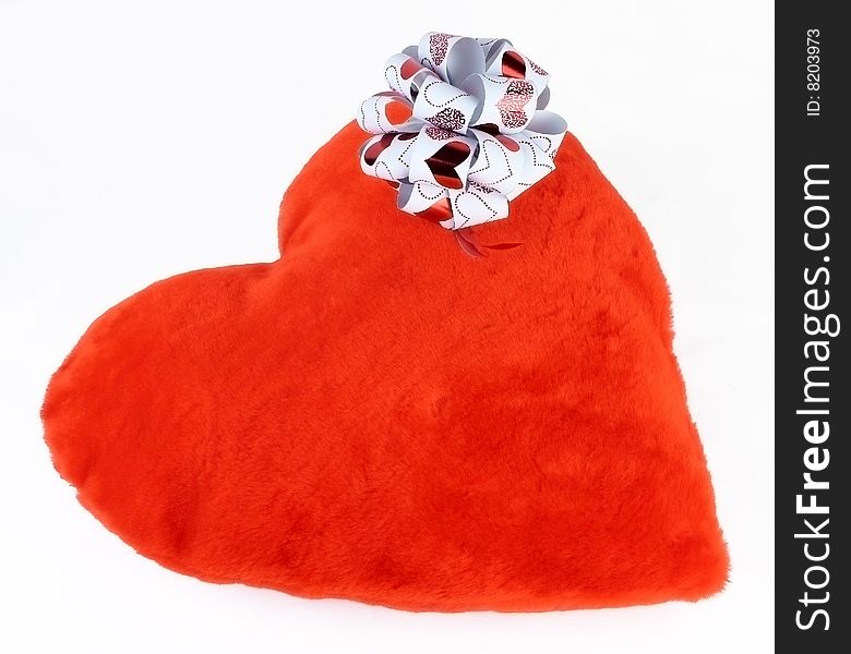Closed-up Red pillow as a heart with bow on it isoleted on a white background. Closed-up Red pillow as a heart with bow on it isoleted on a white background
