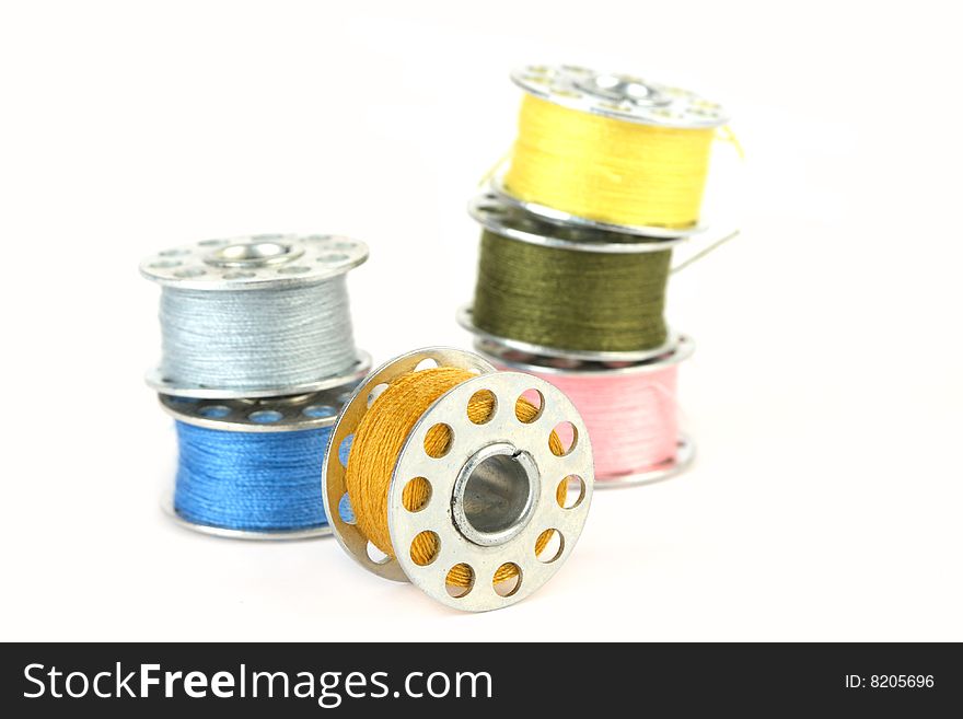 Closeup of colourful spools on  white background