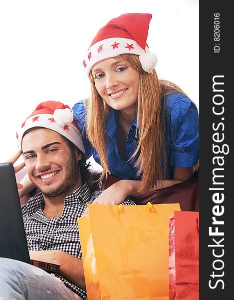 Young couple in Christmas on-line shopping on white background