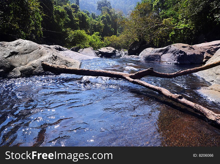 Lake and waterfall in mountains with forest