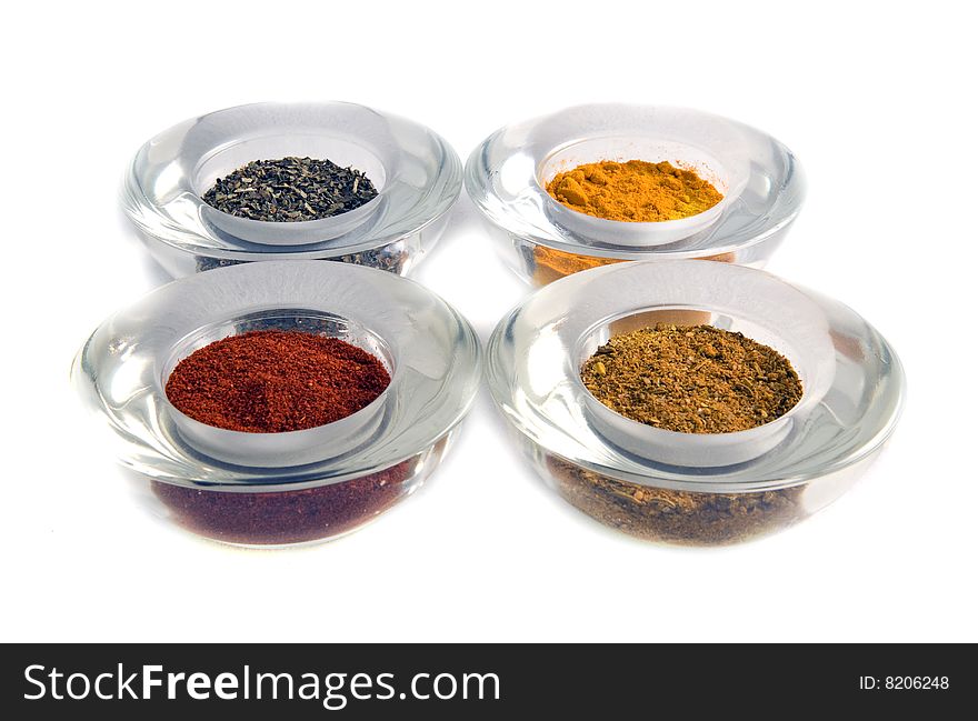 Four colorful spices in glass containers isolated. Four colorful spices in glass containers isolated