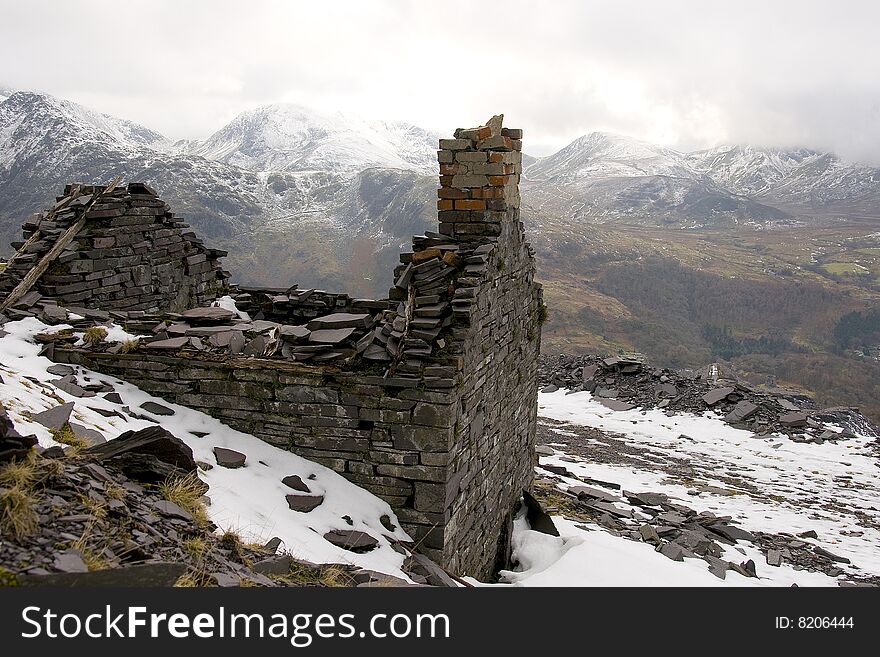 Abandoned buildings in a disused slate quarry in North Wales with a rugged mountain background. Abandoned buildings in a disused slate quarry in North Wales with a rugged mountain background.