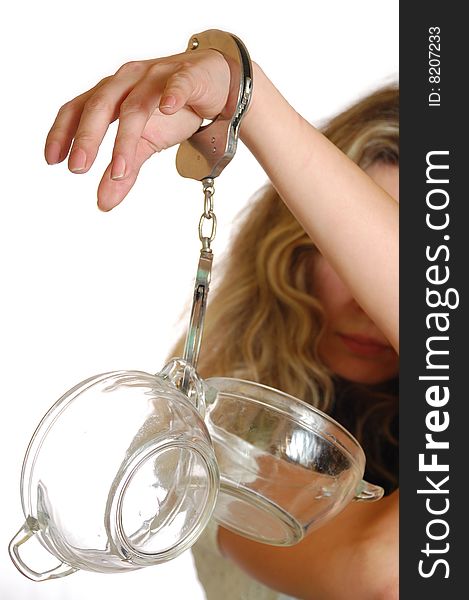 Young exhausted woman chained to pots with handcuffs. Young exhausted woman chained to pots with handcuffs