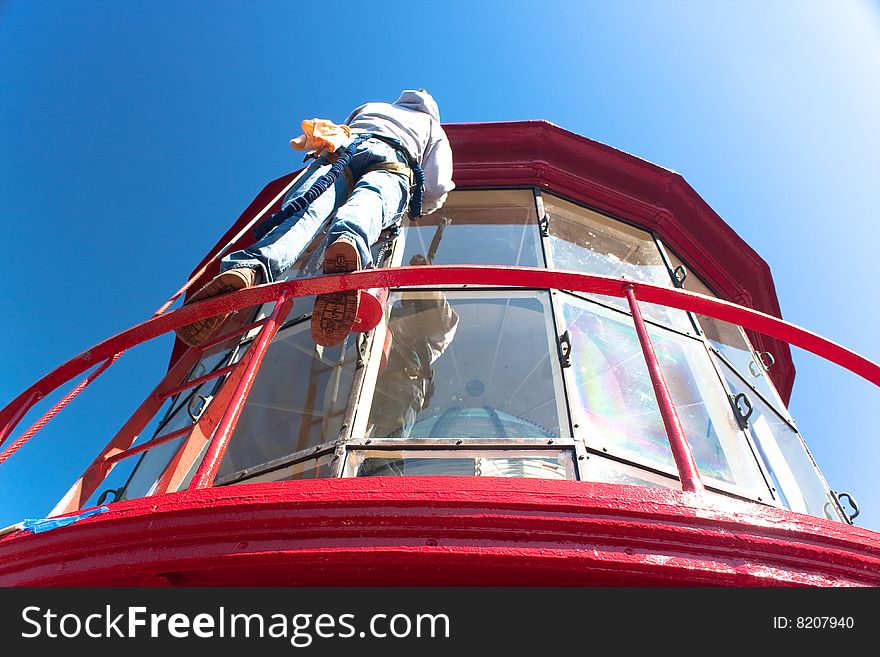 A man doing the dangerous job of painting the top of the St Augustine Lighthouse. A man doing the dangerous job of painting the top of the St Augustine Lighthouse