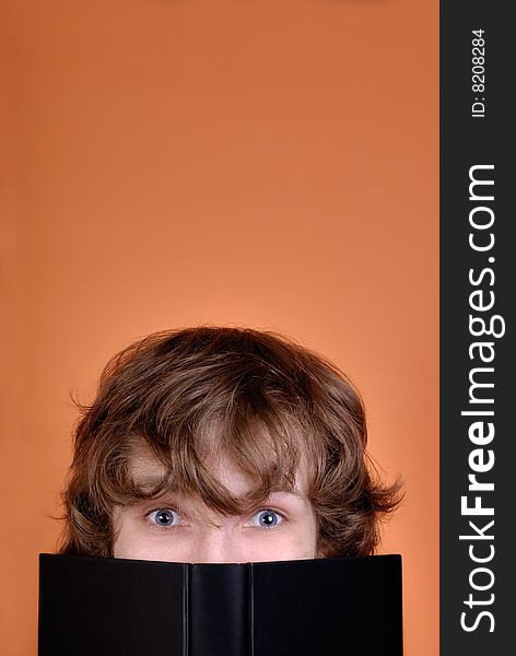 Young man looking over the book with copy space