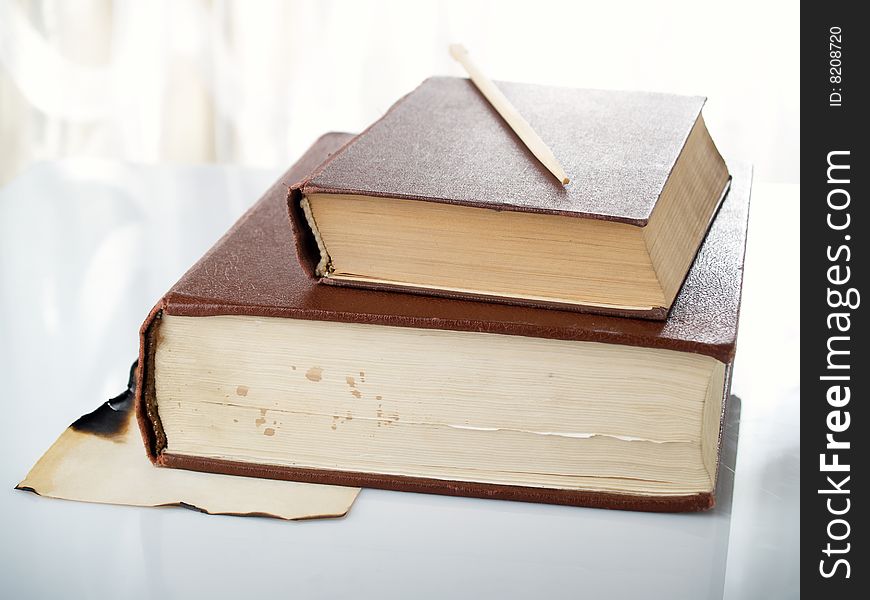 Two old greater books lay on a table. Two old greater books lay on a table