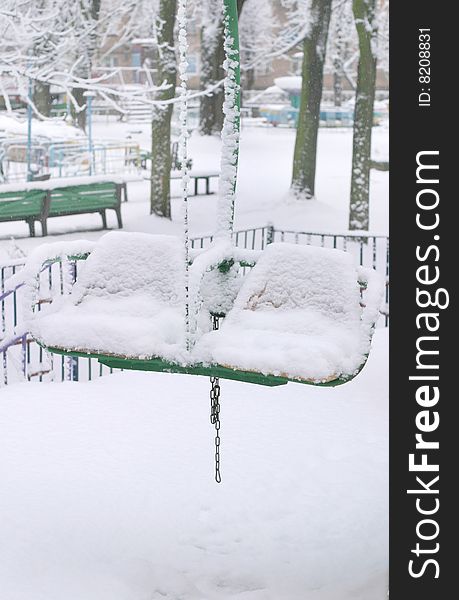 Winter park scene with snowy double chairs